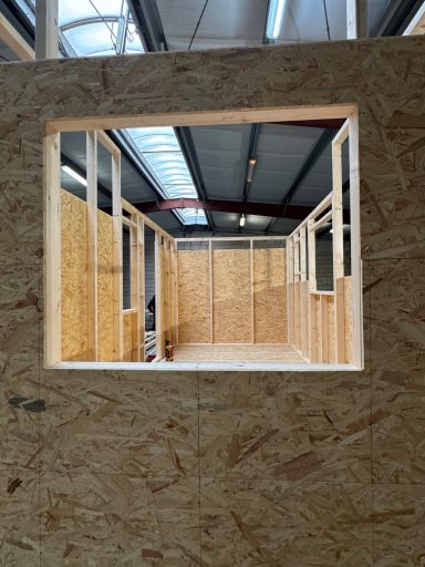 Einblick in ein Tiny House von der Giebelseite durch einen Fensterausschnitt.